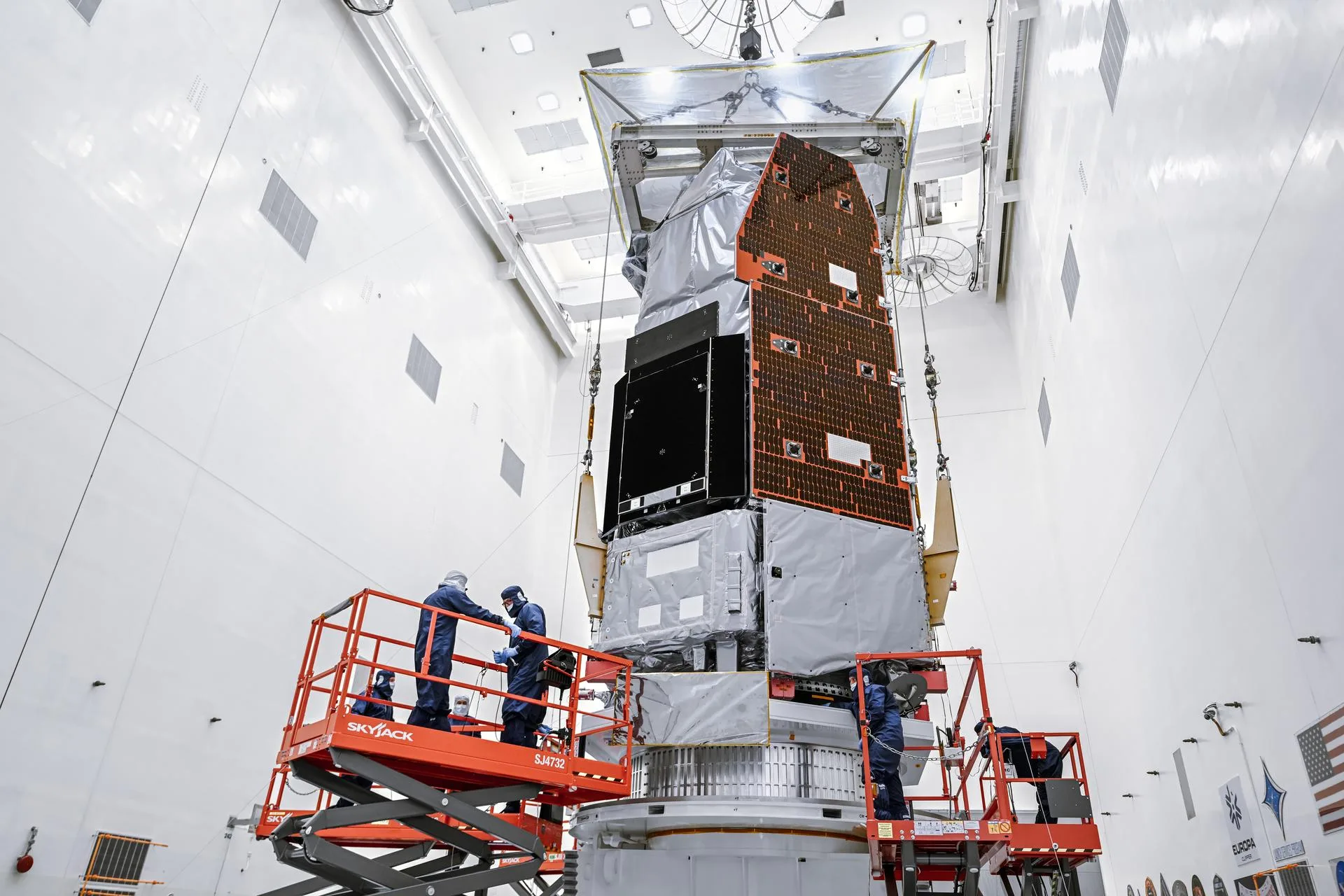 NASA technicians use a crane to lift the Nancy Grace Roman Space Telescope onto a work stand at Kennedy Space Center in June 2026.